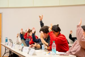 A photo of USG members voting at a USG Senate meeting